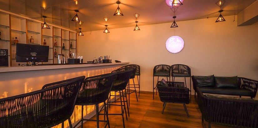 M Cafe with wooden flooring and high chairs lined against the couter table at Vagator Downtown, Goa
