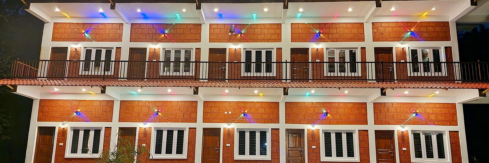 A night time view of the Stoneage Retreat Rooms illuminated by bright lights - Evergreen County
