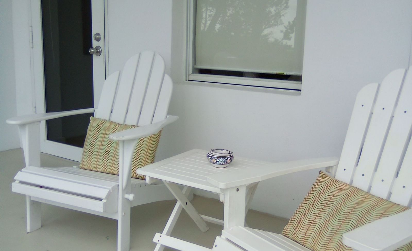 Outdoor seating area at Casa Morada with two white chairs and beige cushions