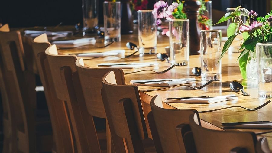 an image of cutlery placed on a  long wooden table 
