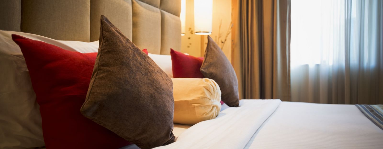 an image of a close up shot of pillows arranged on the bed at The Manor, Bareilly