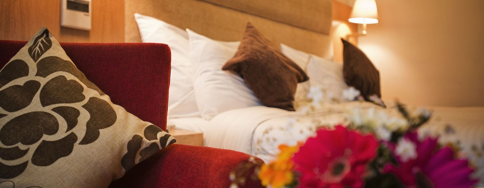 an image of close up shot of flowers placed beside the pillows at The Manor, Bareilly