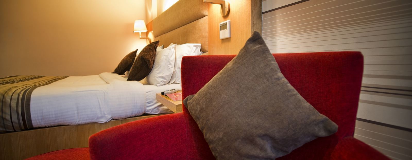 an image of a pillow resting on a chair near the bed at The Manor, Bareilly