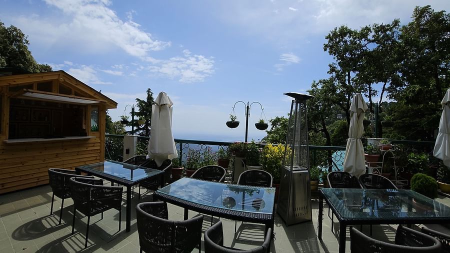 Spacious terrace at Mongas Hotel with multiple dining tables and chairs under clear skies | Mongas Hotel & Resort, Dalhousie 