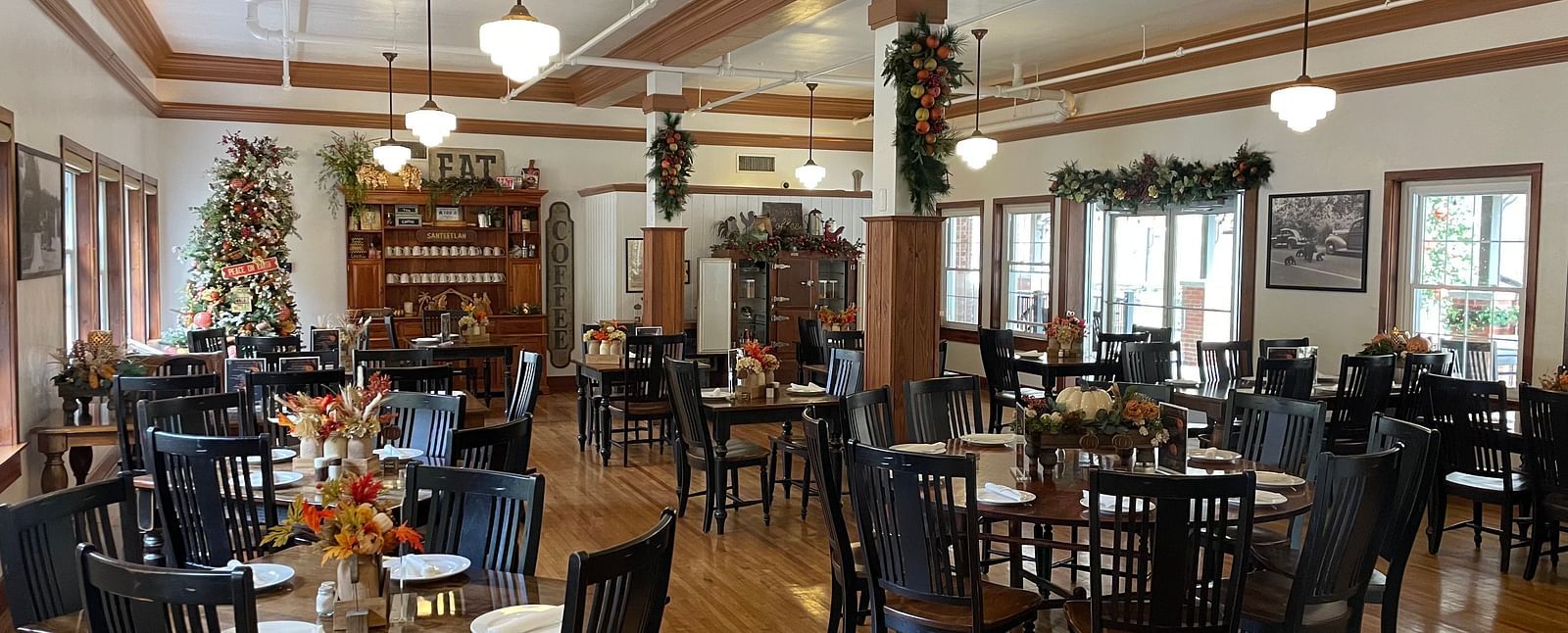 full view image of the Cheoah Dining Room with dark brown colored chairs and tables decorated with well placed cutlery - Historic Tapoco Lodge