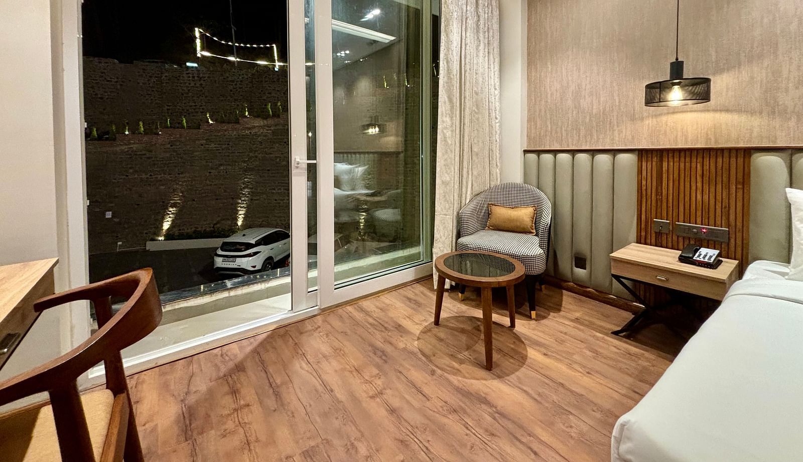 Elegan room with large window, armchairs, and night-time view at ARNISA Boutique Hotel
