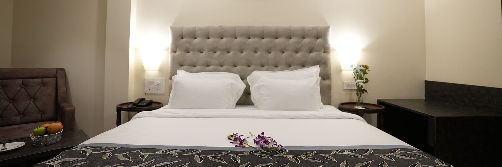 Cosy room setup with a neatly made bed, armchair, and minimalist decor at The Verda de Miranda Resort.
