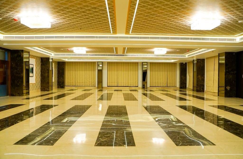 An expansive and brightly lit banquet hall, showcasing its patterned floor tiles and elegant ceiling design.