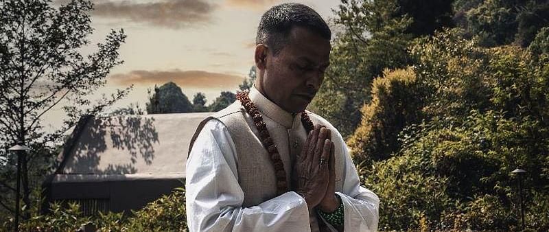 A man meditating in an open area, sitting on the grass | Kavya Resort & Spa, Nagarkot