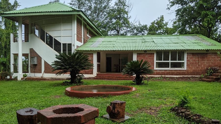 Exterior view of The Conservancy Bungalow with a green roof and a firepit in the lawn.