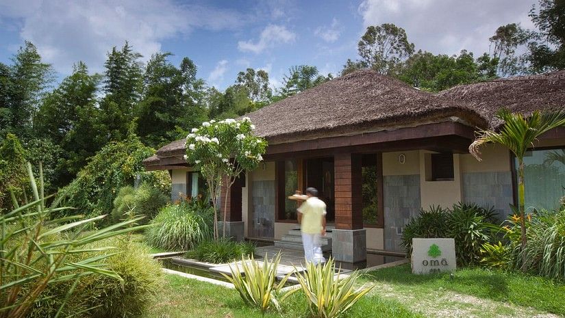 A staff walking next to the entrance of Oma spa in Kabini at The Serai Kabini.
