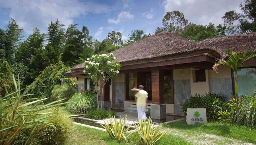 A staff walking next to the entrance of Oma spa in Kabini at The Serai Kabini.