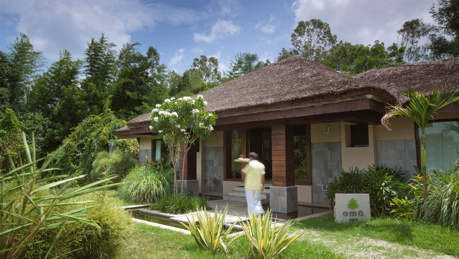 A staff walking next to the entrance of Oma spa in Kabini at The Serai Kabini.