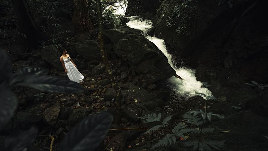 a woman looking at a white stream near - Holistic Stay Eco Resort, Kannur