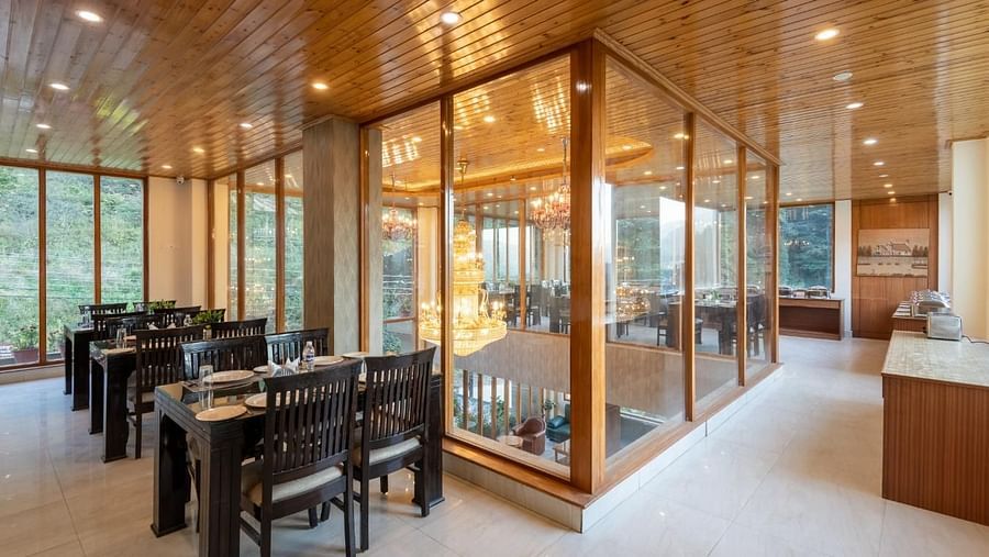 Image of a  spacious restaurant with large windows overlooking a scenic view  | DLS Serenity Resort and Spa