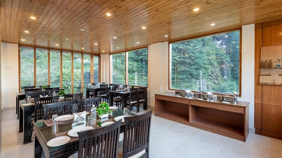 Image of a  spacious restaurant with large windows overlooking a scenic view  | DLS Serenity Resort and Spa