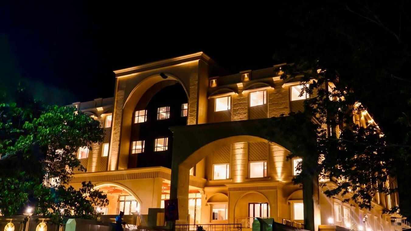 Facade of Le Royale Palace with trees on either sides of the building.