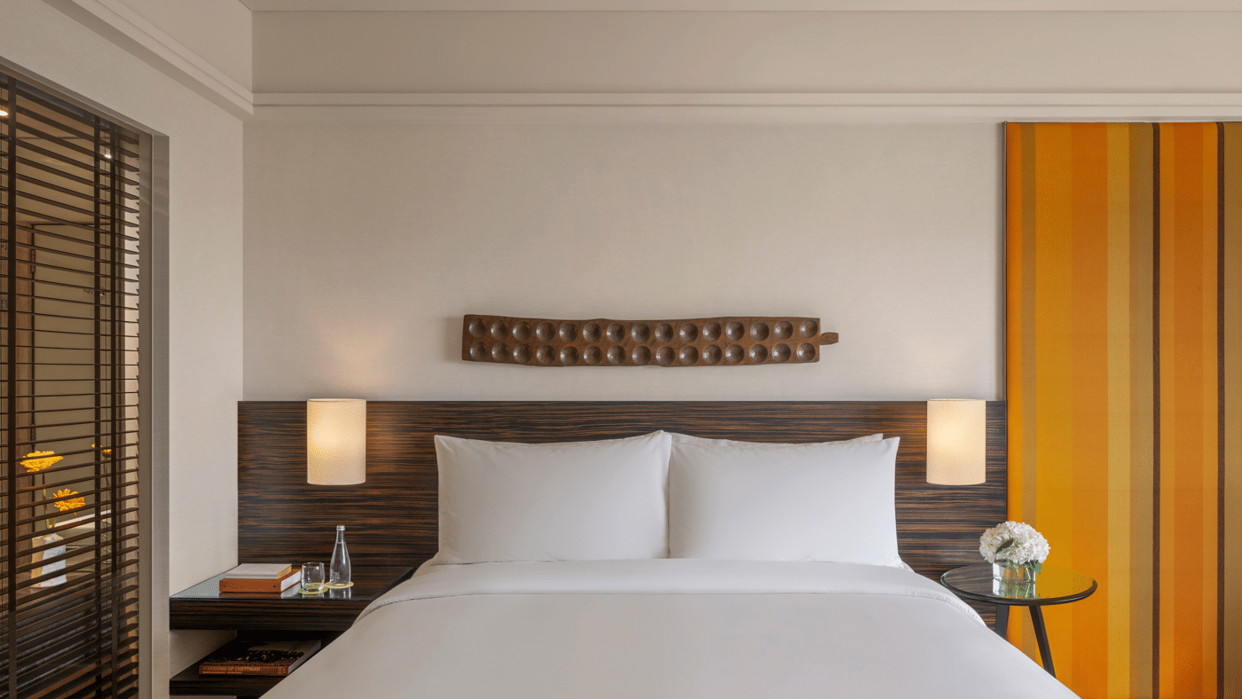 Bed with lamps and wall paneling at The Raintree, St. Mary’s Road.