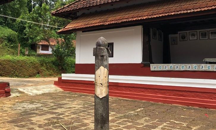 Traditional Kodava Ainmane ancestral home with greenery.