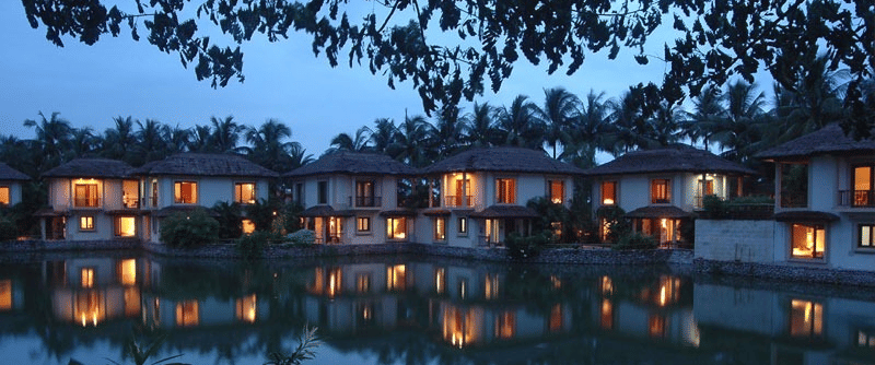 A picturesque night scene of illuminated buildings reflected in a calm body of water