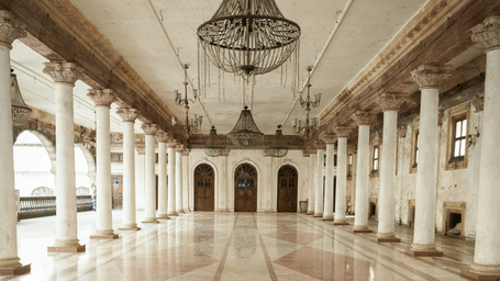 An interior view of Rajwada Palace, Indore, Madhya Pradesh, with a chandelier on the roof and numerous beams. This palace is one of the beautiful places in Indore to visit.