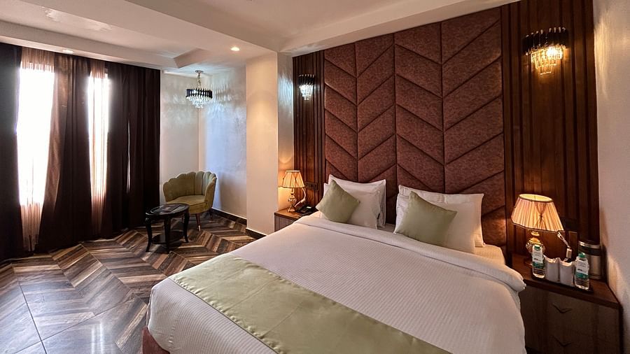 Image of Super Deluxe Room featuring a double bed with a nightstand next to it  as the sunlight makes its way into the room through the curtains - DLS Grand Luxotica, Dehradun