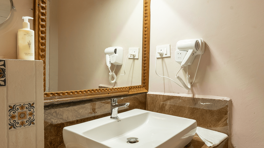 Clean and modern bathroom vanity with a large mirror and white vessel sink at Maati Resort By The Lake Hill, Jeolikote.