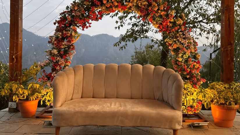 Floral arch decorated with flowers framing a beige sofa seating area at The Manor Luxury Apartments, Shimla.