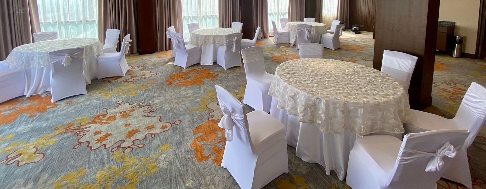 Banquet hall featuring round table seating arrangements.