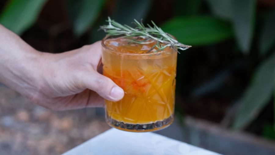 A person holding a glass of a drink next to Potato Fries | Mango Hill, Pondicherry