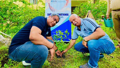 Group of people planting a sapling on the resort grounds at Vedic Village Spa Resort.