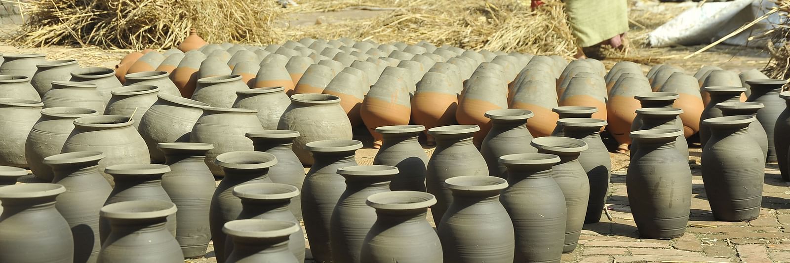 A pottery lined up on a ground which are kept for drying under the sun