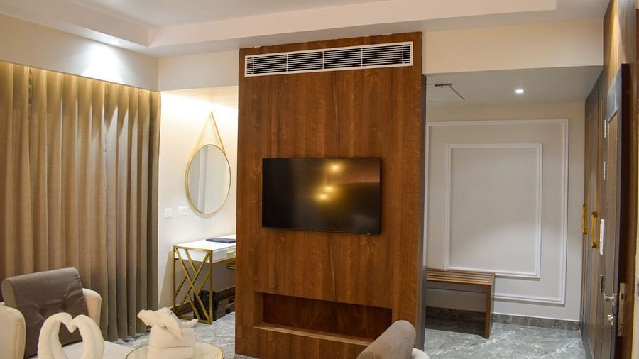 A wall mounted tv on a wooden wall inside the suite at Tulip Inn, Shravasti