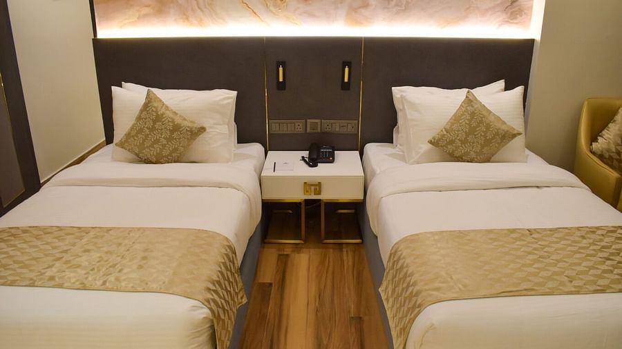 Close up shot of the twin beds and the side table inbetween inside executive room at Tulip Inn, Shravasti
