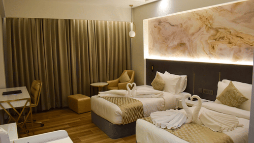 Twin beds with stydy table and sofa inside executive room at Tulip Inn, Shravasti