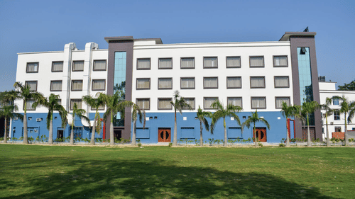 lawn area with coconut trees and Tulip Inn, Shravasti in the background