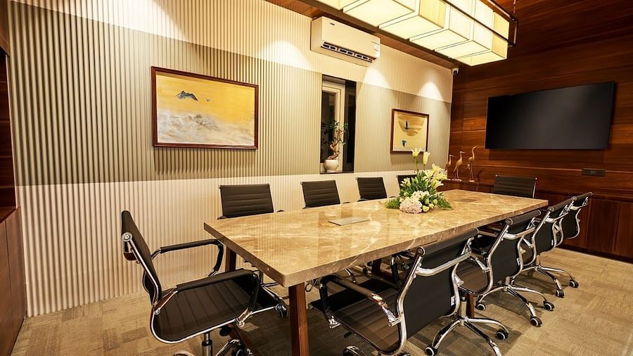 A conference room setting with a centre table and black chairs around it at the boardroom at Visthara - Urban Boutique Hotel