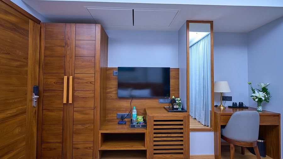 Image of cupboards, dressing table, television and a chair in a room at Visthara - Urban Boutique Hotel, Bangalore