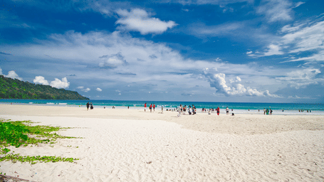 A wide angle shot of the Radhanagar Beach with a white sands coastline in the foreground.