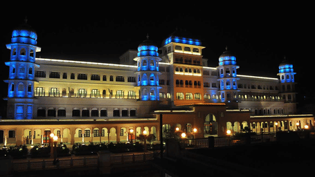 An elegant hotel building at night with a large light display.