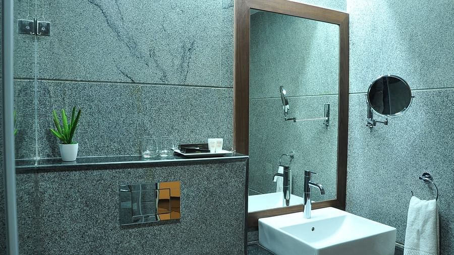 Bathroom of Executive Room at Dhanalaksmi Srinivasan Hotels, Perambalur featuring a sink area in the corner along with a mirror.
