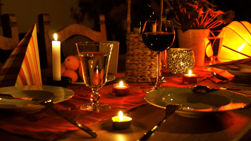 a table spread out with dinner plates and a glass of wine