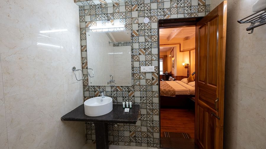 Washroom with a sink and a wall-mounted mirror at Himalaya Hotel, Nainital
