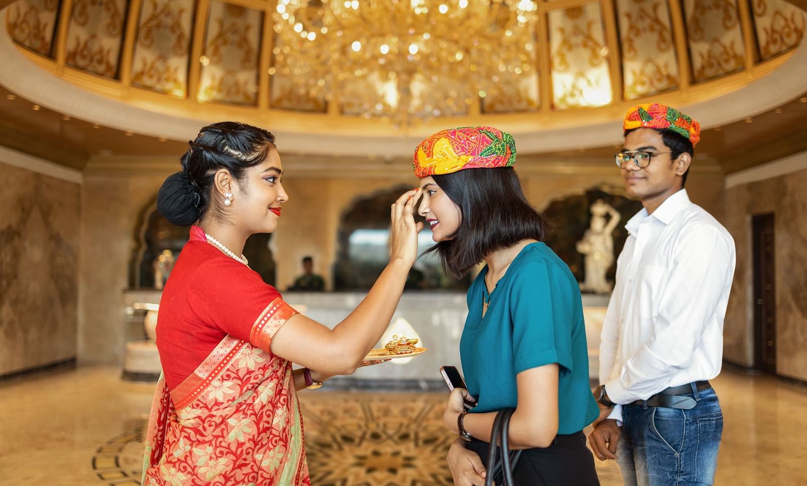 A woman dressed in red welcoming our guests in the traditional Rajasthani way - Kaldan Samudhra Palace, Mahabalipuram