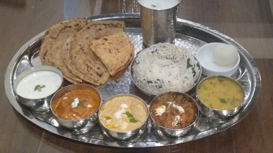 A beautifully arranged Punjabi thali featuring a variety of delicious Indian dishes served at Cafe, Matsya Island Retreat. The vibrant plates include traditional curries, rice, bread, and sides, all set against a serene backdrop of the retreat.