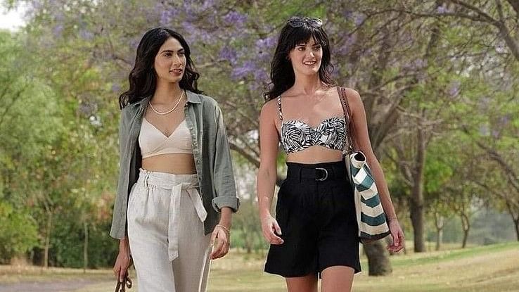 Two women walking on a pathway next to the lawn area - Karma Lakelands.