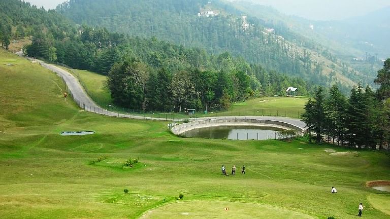 Scenic golf course with rolling green fairways, mountain views, and circular putting green at The Manor Wellness & Sports Hotel