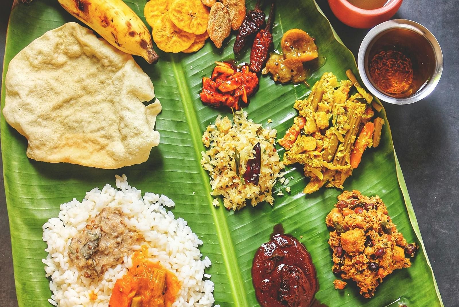 image of a various traditional malayali delicacies served on a banana leaf