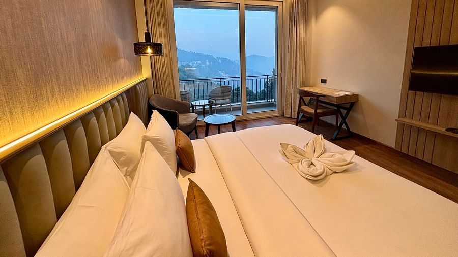 Elegant bedroom with a double bed, ambient lighting, and a large window showing a mountain view –ARNISA Boutique Hotel