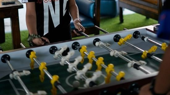 Woman enjoying foosball at inflated trampoline surrounded by trees at Themis Mudhouse - A Nature's Retreat Resort & Wellness